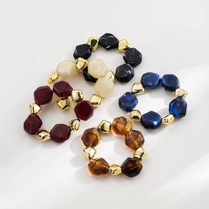 Close-up of colorful beaded bracelets featuring irregular marbled resin and gold beads