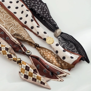 Dettaglio di sciarpe in seta vintage con stampe paisley e pois e fibbie in metallo