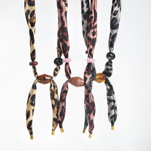 Detail of leopard print scarf necklaces with resin beads and gold metallic end caps