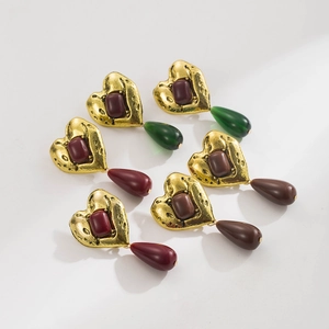 Detalle de pendientes de corazón en oro martillado con colgantes en forma de gota