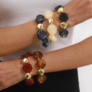 Multi-colored geometric resin beaded bracelet with gold spacers for a vintage look