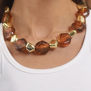 Retro amber resin and golden geometric beads chunky necklace worn on a white top