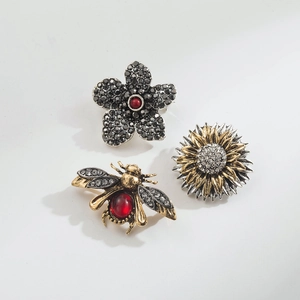 Detailed view of vintage crystal floral and bee brooches with rhinestones and red gems