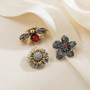 Detailed view of vintage bee, sunflower and floral brooches with rhinestones and crystals