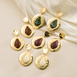 Detail of four pairs of vintage geometric metal earrings with colorful resin water drops