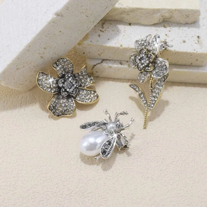 Close-up of luxury sunflower and bee brooches with rhinestones and white pearls