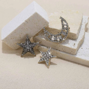 Detailed view of rhinestone-encrusted star and crescent moon brooch set in gold