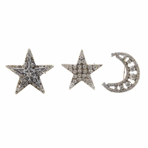 Macro detail of rhinestone-encrusted star and crescent moon silver brooch set for clothing