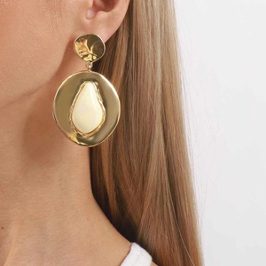 Exaggerated geometric gold hoop earrings with white teardrop enamel and hammered texture