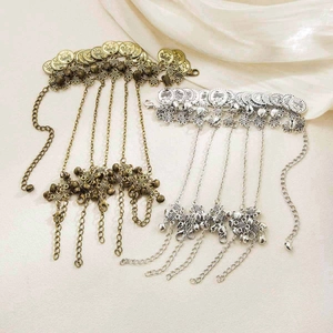 Detailed view of bohemian ethnic headpieces with vintage coins and bells in gold and silver