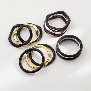 Dettaglio di bracciali geometrici minimalisti in oro, argento e nero opaco di alta qualità