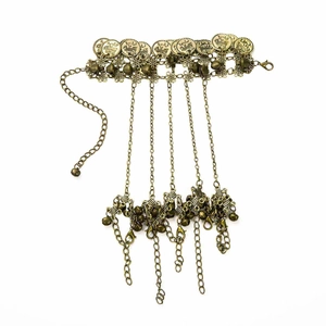 Detail of vintage bohemian bracelet with copper coins, bells and intricate floral links