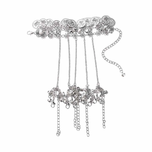 Detail of silver bohemian finger bracelet with vintage coins and small bell charms