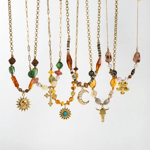 Detail view of gold layered necklaces with bohemian beads and symbolic charms