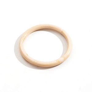 Gros plan détaillé du bracelet en acrylique ivoire avec texture marbrée et finition brillante