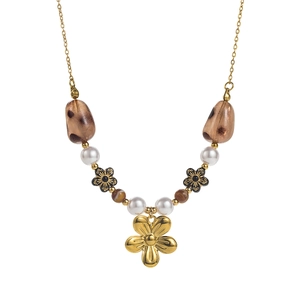 Close-up of vintage gold necklace featuring a floral pendant and mixed leopard beads