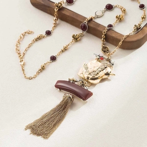 Detailed close-up of vintage tassel pendant necklace with golden beads and floral accents