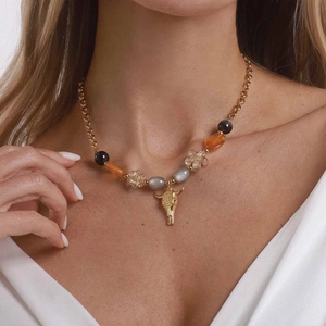 Bohemian mixed bead necklace featuring a gold cow skull pendant and floral engravings