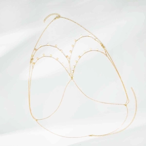 Macro detail of multi-layer gold chain body jewelry with small circular sequins