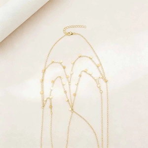 Detail of golden multi-layer body chain with round sequins and lobster clasp closure