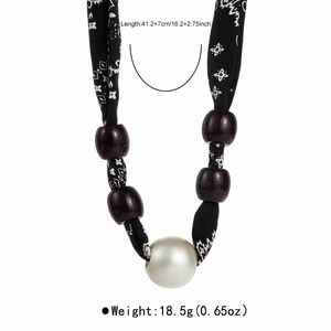 Detail of leopard print silk scarf necklace with wooden beads and a large faux pearl