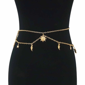 Detail of gold double-layer waist chain featuring sun, moon, and star charms for women