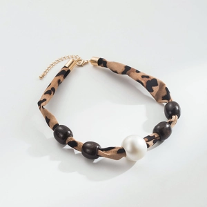 Close-up of leopard print fabric necklace with white pearl and dark wood beads