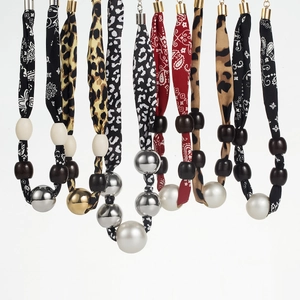 Close-up of leopard and zebra print fabric necklaces with pearls and metallic beads