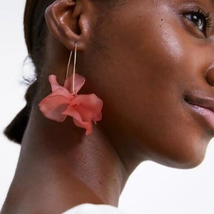 Macro shot of a long fashion flower earring in translucent resin on model