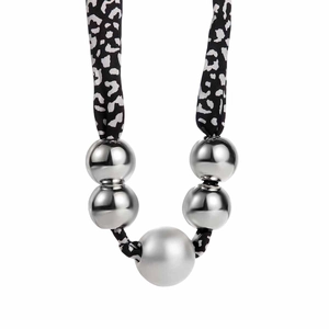 Detailed view of leopard print fabric necklace with five polished silver metal beads