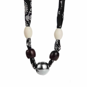 Detail of leopard print fabric strap necklace with white beads and large polished silver ball