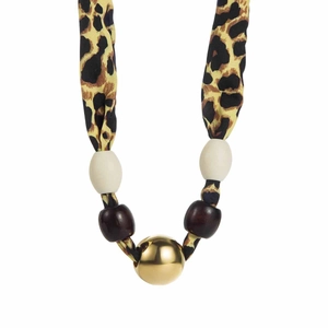 Detailed close-up of leopard print fabric necklace with gold metal sphere and beads
