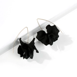 Detail showing matte black layered flower petals and elegant golden hook earrings