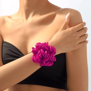 Makroansicht einer großen magentafarbenen Rosen-Stoff-Handgelenks-Corsage am Modell