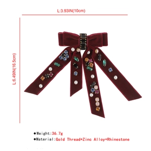 Detailed view of deep red velvet double bow hair clip with rhinestones and pearls