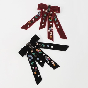 Macro view of velvet bow hair clips with embedded rhinestones and pearls