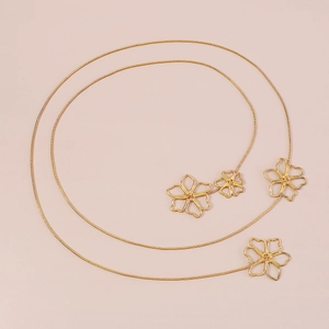 Detailed macro view of the gold snake chain featuring hollow flower accents and high shine