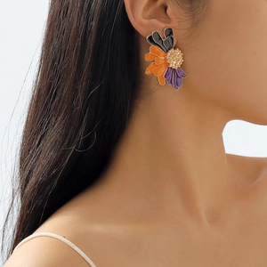 Detail of vintage flower stud earrings featuring colorful enamel petals on a female model