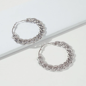 Macro detail of polished silver chunky chain-link hoop earrings in punk style