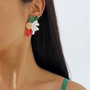 Close-up of floral enamel stud earrings in red, white and green on a model