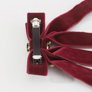 Detail of burgundy velvet double bow hair clip with sparkling gemstone accents