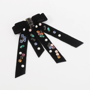 Detail of black velvet double-layer bow hair clip with colorful rhinestones and pearls