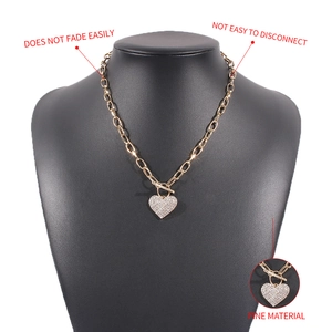 Detail of gold heart pendant with rhinestones and durable OT toggle clasp on metal chain