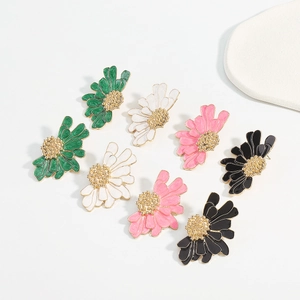 Detail view of colorful floral stud earring set with green white pink and black petals