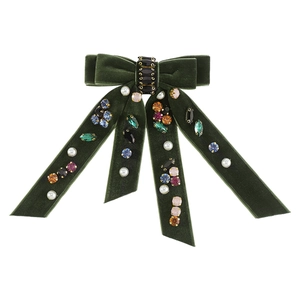 Detailed macro view of dark green velvet bow hairpin with colorful rhinestones and pearls