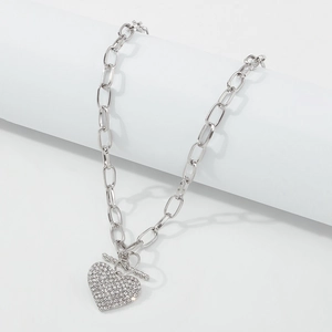 Detail of silver link chain necklace with crystal heart pendant and toggle clasp