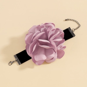 Vue détaillée d'une rose en tissu violet clair sur un collier ras du cou en velours noir