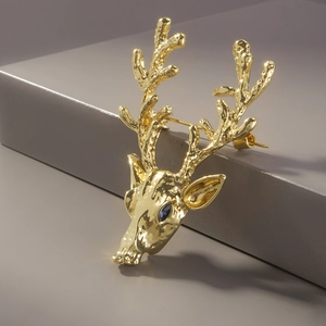 Elegant gold deer head brooch with blue gemstone eye and hammer texture finish