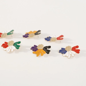 Detail view of colorful enamel daisy flower stud earrings with golden textured centers