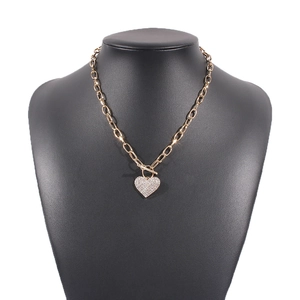 Gold chain necklace with sparkling heart pendant and toggle clasp on black bust